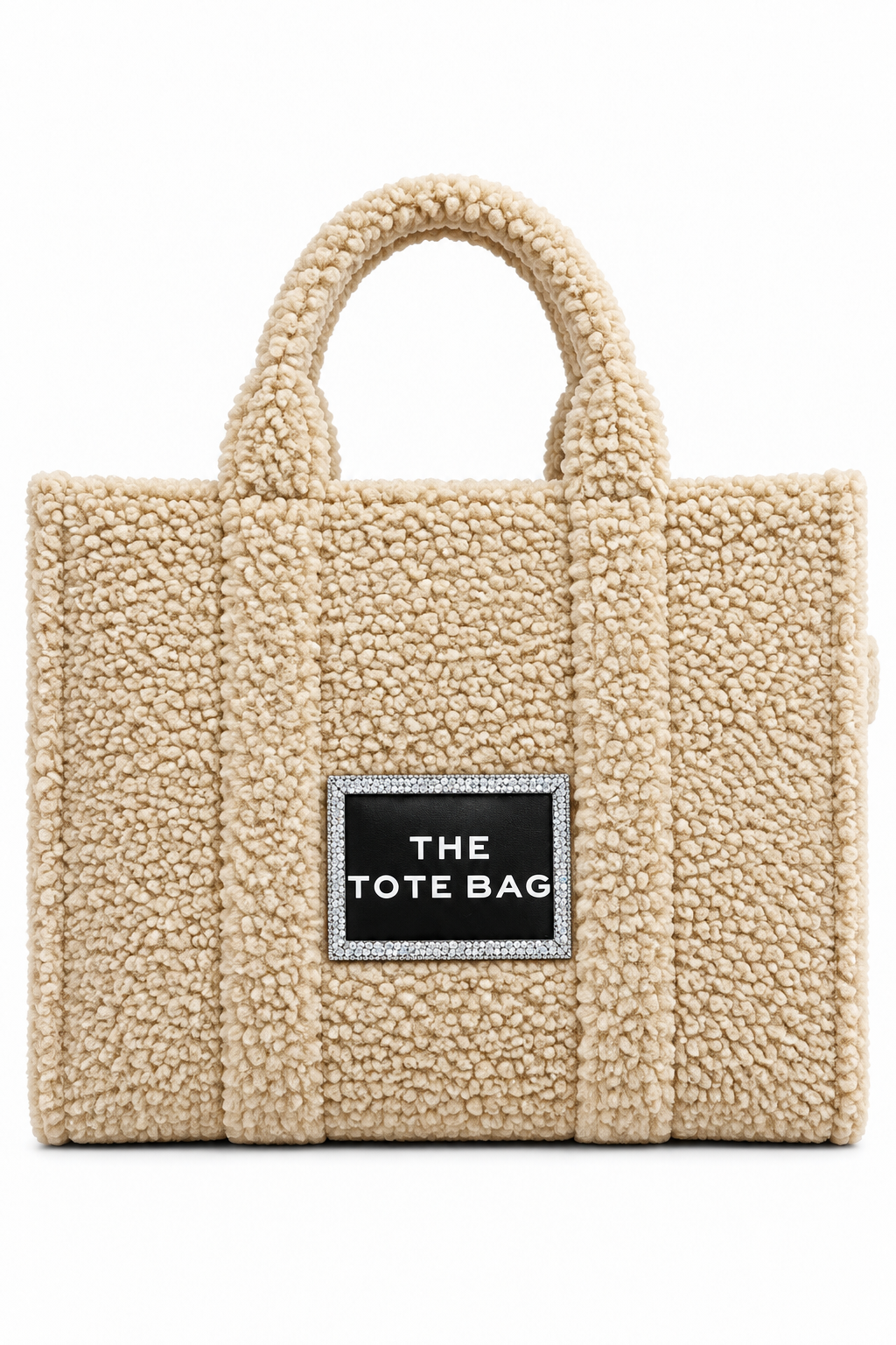 A beige teddy-textured tote bag with dual top handles and a black rectangular front patch that reads &