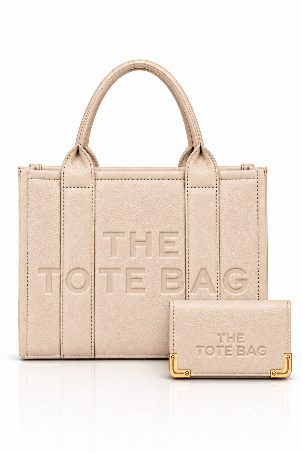Nude textured tote bag with short rounded handles, matching vertical from straps, embossed "THE TOTE BAG" lettering, paired with a matching silver zip around wallet. Set on a white background.
