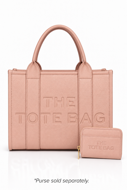 Metallic Pink faux leather structured tote bag with two rounded top handles, embossed. "THE TOTE BAG" lettering on the front, vertical stitched panels, contrast edging stud details. 