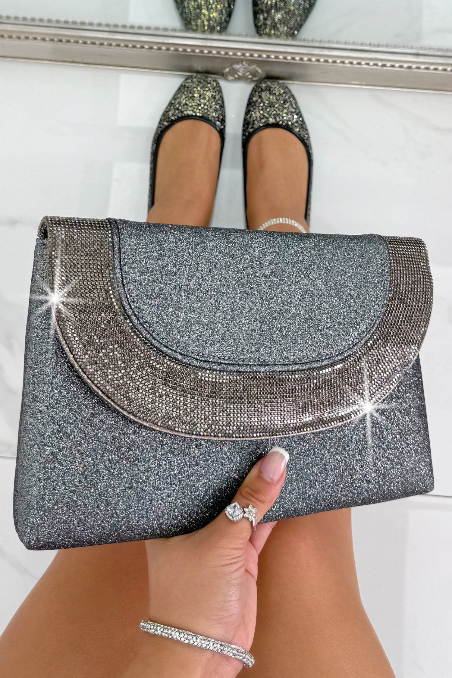 Glitter Luxe Metallic Crystal Envelope Clutch Bag Grey, drawing attention to sleek envelope-style flap with crystal embellished detail showcasing a sleek envelope silhouette with sparkling crystal embellishments.