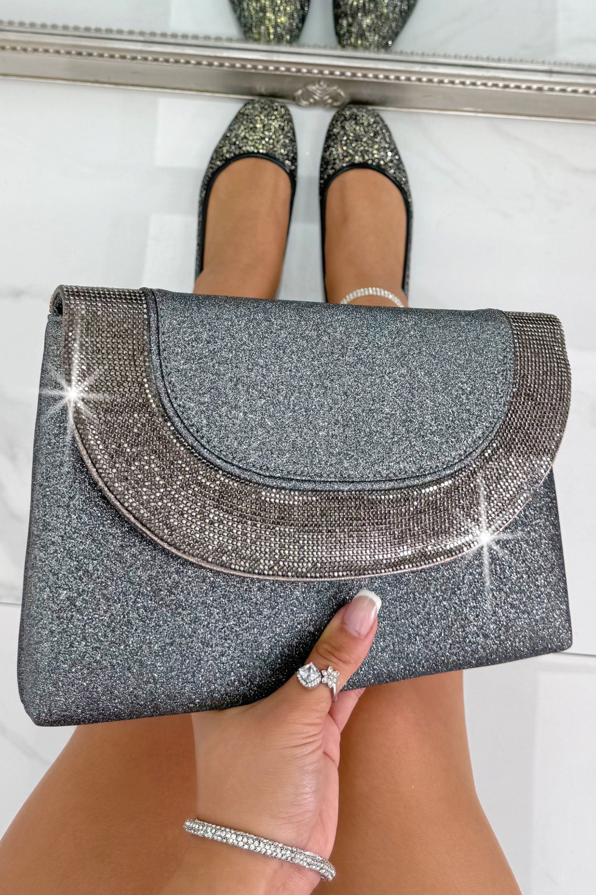 Glitter Luxe Metallic Crystal Envelope Clutch Bag Grey, drawing attention to sleek envelope-style flap with crystal embellished detail showcasing a sleek envelope silhouette with sparkling crystal embellishments.