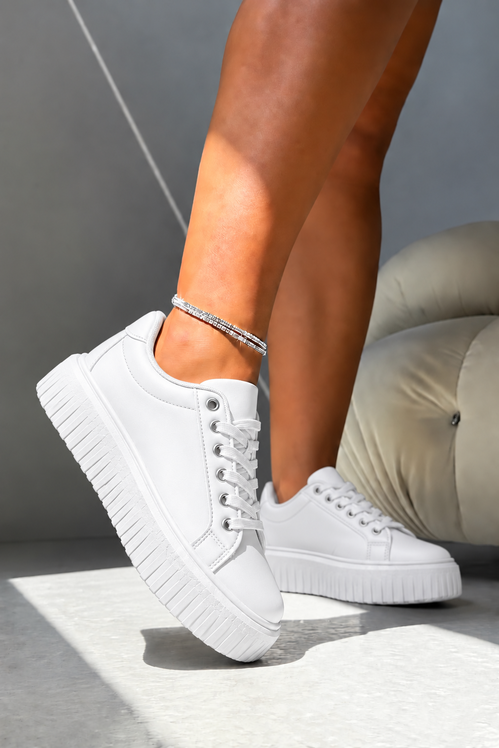 White low-top platform sneakers with white laces and thick lug soles, shown on a model&