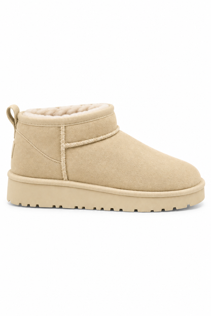 A single beige suede ankle boot with a thick platform sole and a soft fleece lining, shown from a side profile on a white background.