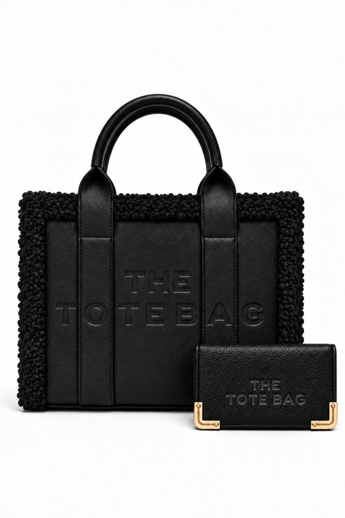 Black tote bag bundle featuring a structured handbag with rounded top handles, textured trim, embossed "THE TOTE BAG" lettering, and matching black straps. Includes a matching black purse with embossed branding and gold-tone corner detailing.