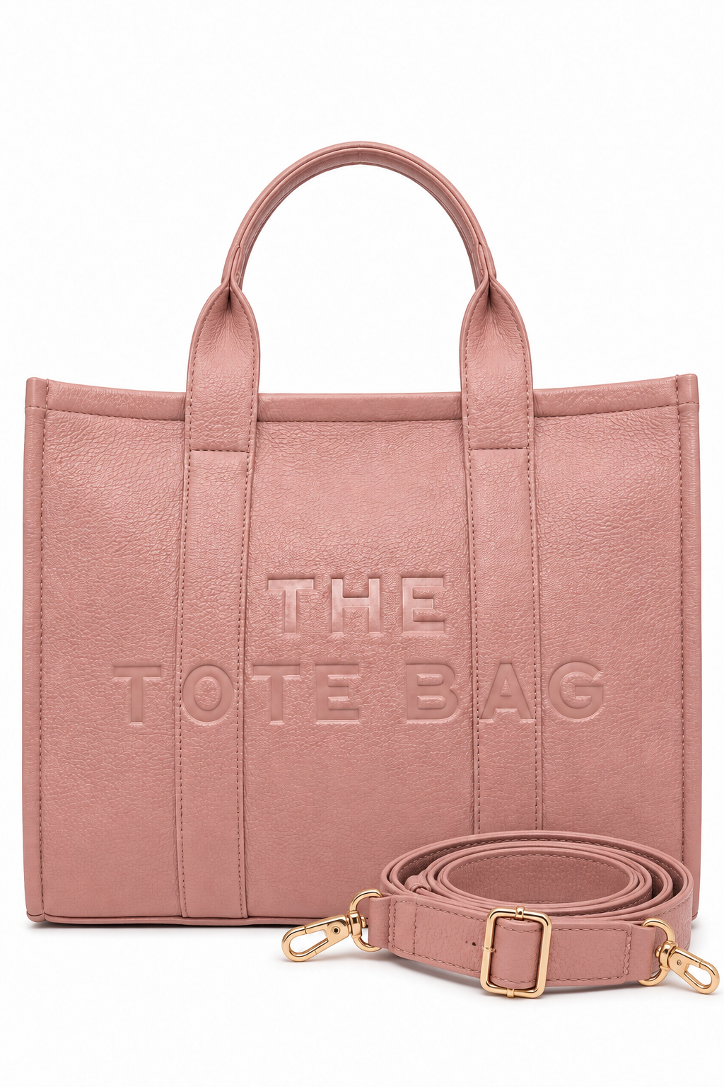 Large Pink faux leather structured tote bag with two rounded top handles, embossed. "THE TOTE BAG" lettering on the front, vertical stitched panels. Pictured on a white background.  With pink-tone strap pictured in front of the bag.