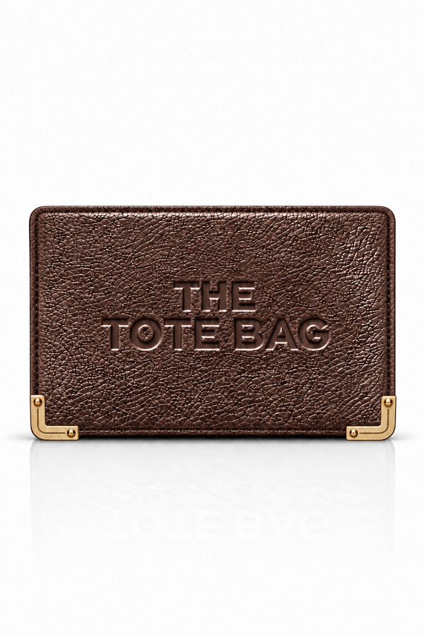 Dark brown textured tote purse with embossed lettering on the front and gold-tone metal corner protectors with rivet detailing. Set against a plain white background.
