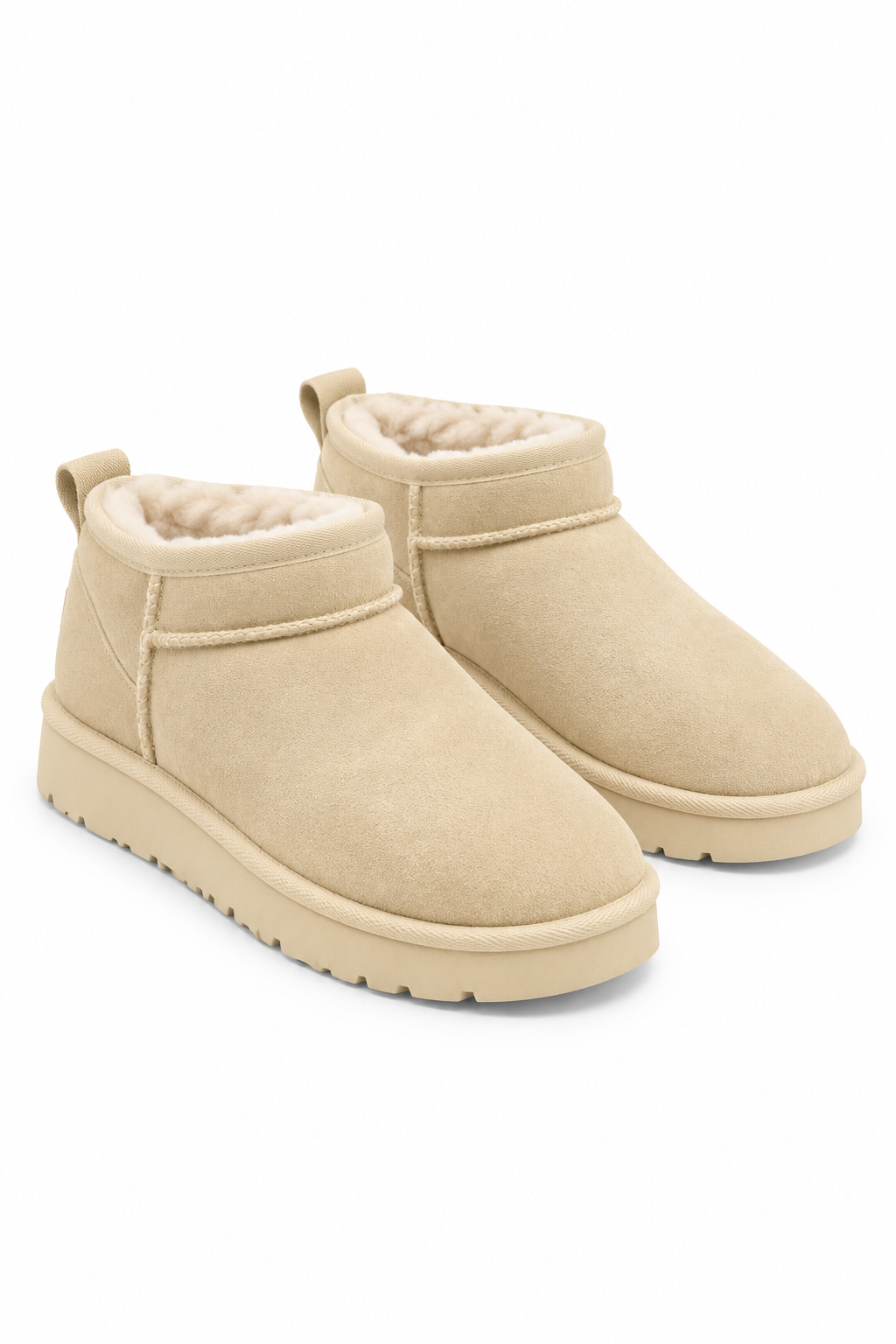 A pair of beige suede ankle boots with plush cream shearling lining, shown from a three-quarters angle on a white background.