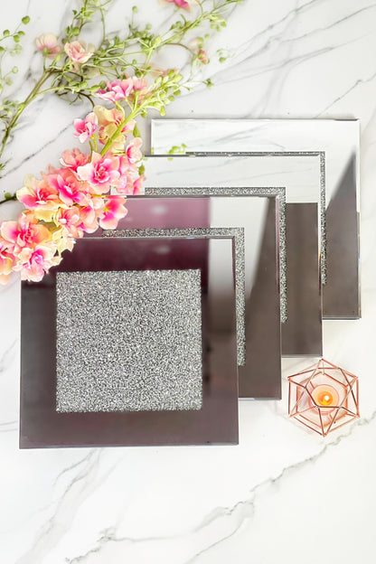 A set of four glittering coasters against a marble backdrop
