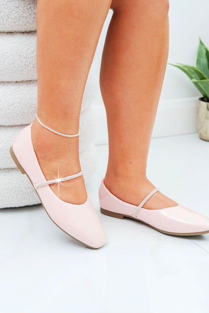 Light pink flat shoes worn with a white background