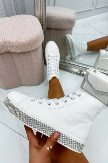 Person holding a white sneaker with gray sole in front of a mirror.