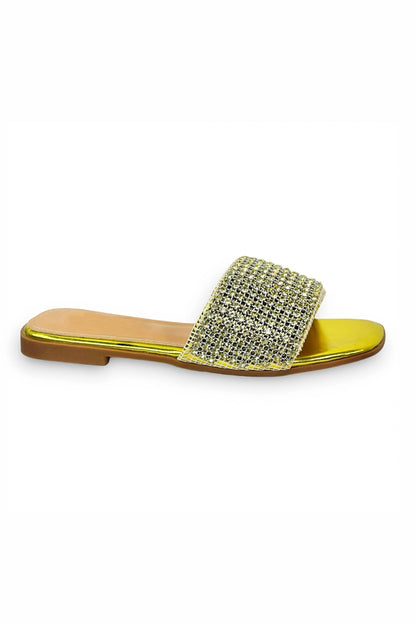 Yellow sandals, embellished, against a white backdrop