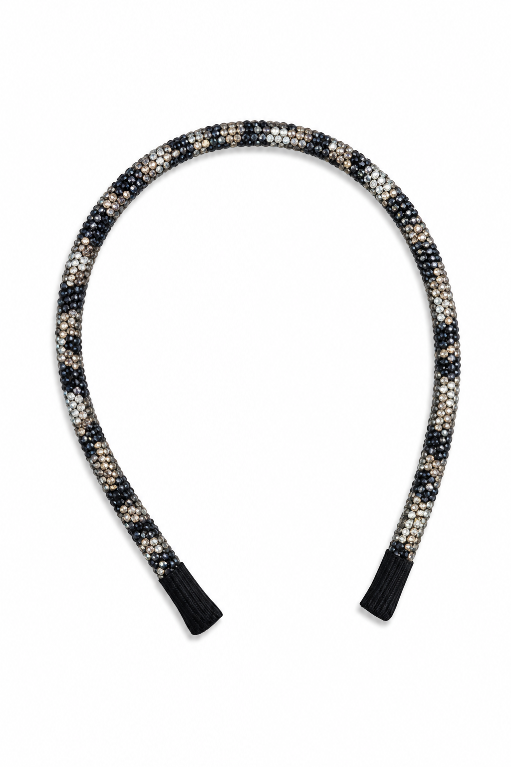 A braided headband with a black, white, and beige leopard pattern, finished with solid black fabric tips, shown on a plain white background.