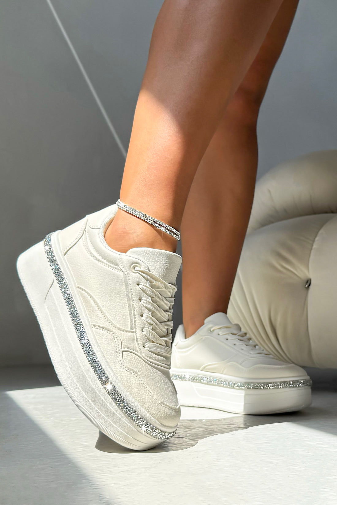 Nude sneakers with decorative elements on a neutral background