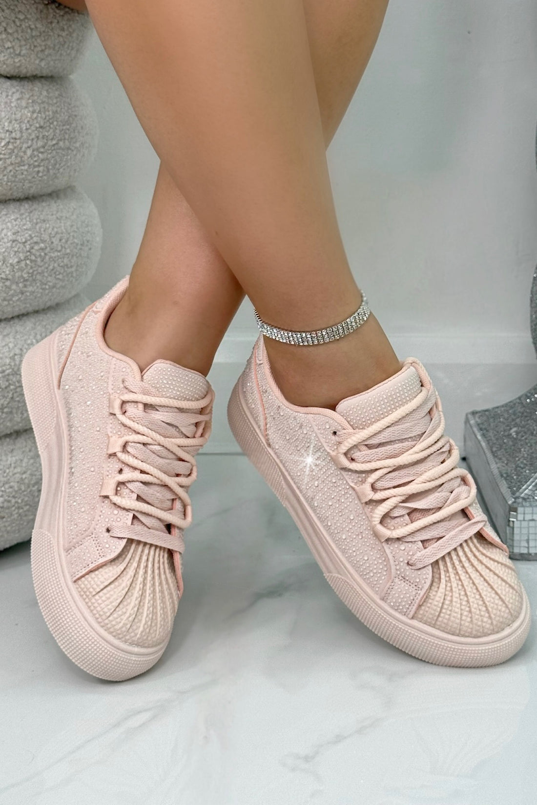 Pink sneakers worn on a light gray background