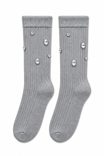 A pair of light gray ribbed crew socks decorated with scattered clear rhinestone embellishments, displayed against a solid white background.