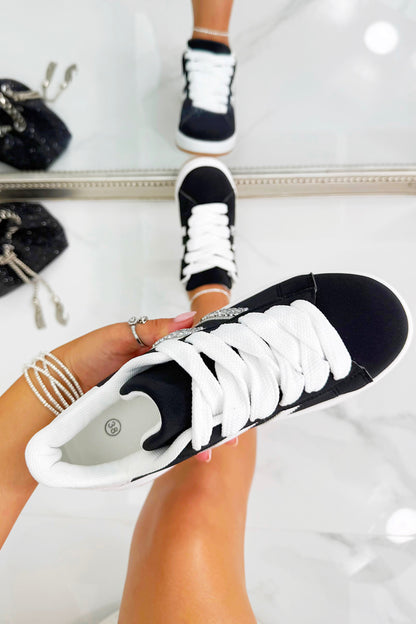 Black and white sneakers being worn with a blurred background