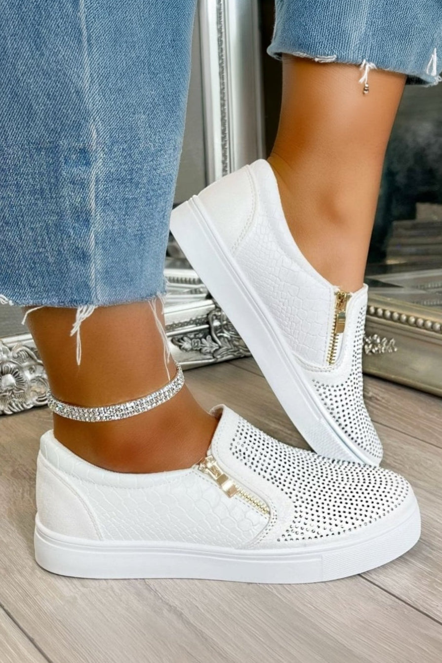 White sneakers with rhinestone embellishments worn with blue jeans.