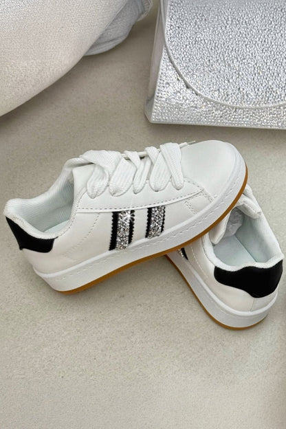 White sneakers with black stripes on a light surface