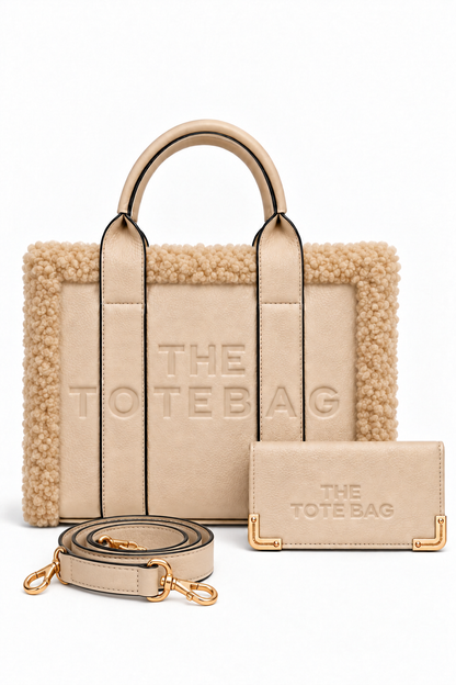 Nude Tote bag featuring a plush cream bouclé trim, structured silhouette, long top handles with black edging, and raised tonal lettering on the front. Nude Tote purse pictured in front. Set against a white background.