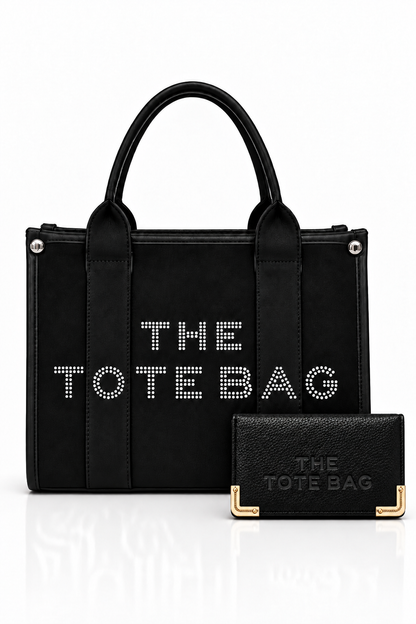 Black, structured tote bag with short rounded handles, textured panel, silver-tone stud details and embellished "THE TOTE BAG" lettering on the front, paired with matching black textured wallet with gold tone corner protectors.