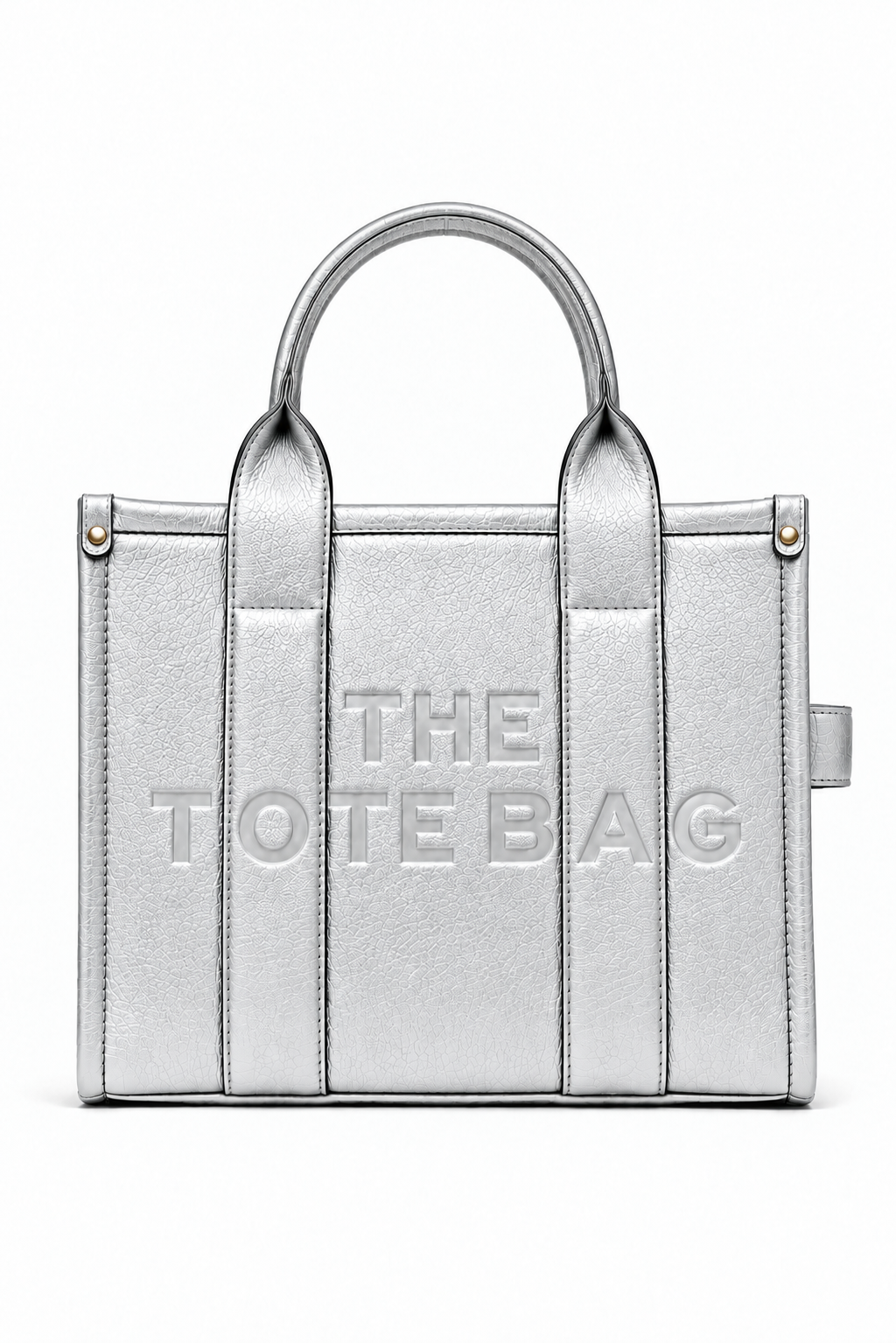 Metallic Silver faux leather structured tote bag with two rounded top handles, embossed. "THE TOTE BAG" lettering on the front, vertical stitched panels, contrast edging and silver- tone stud details. 