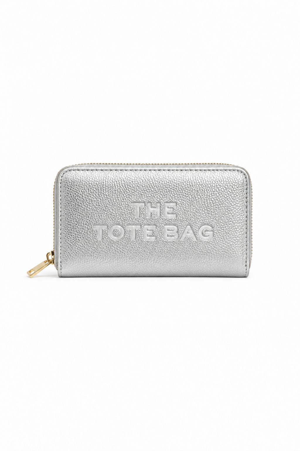 Metallic Silver rectangular zip-around purse with embossed "THE TOTE BAG" lettering on the front, contrast stitching around the edges and a gold-tone zip fastening with a matching pull tab. Set against a plain white background.