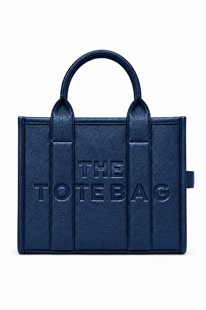 A navy blue faux-leather tote bag with embossed vertical panel details and the text &