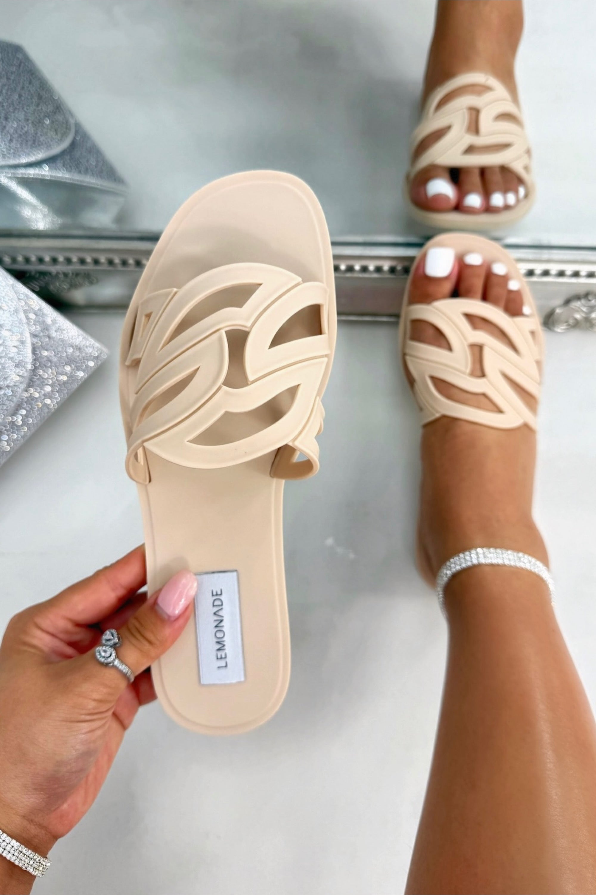 Beige sandals with a brand label on a white surface