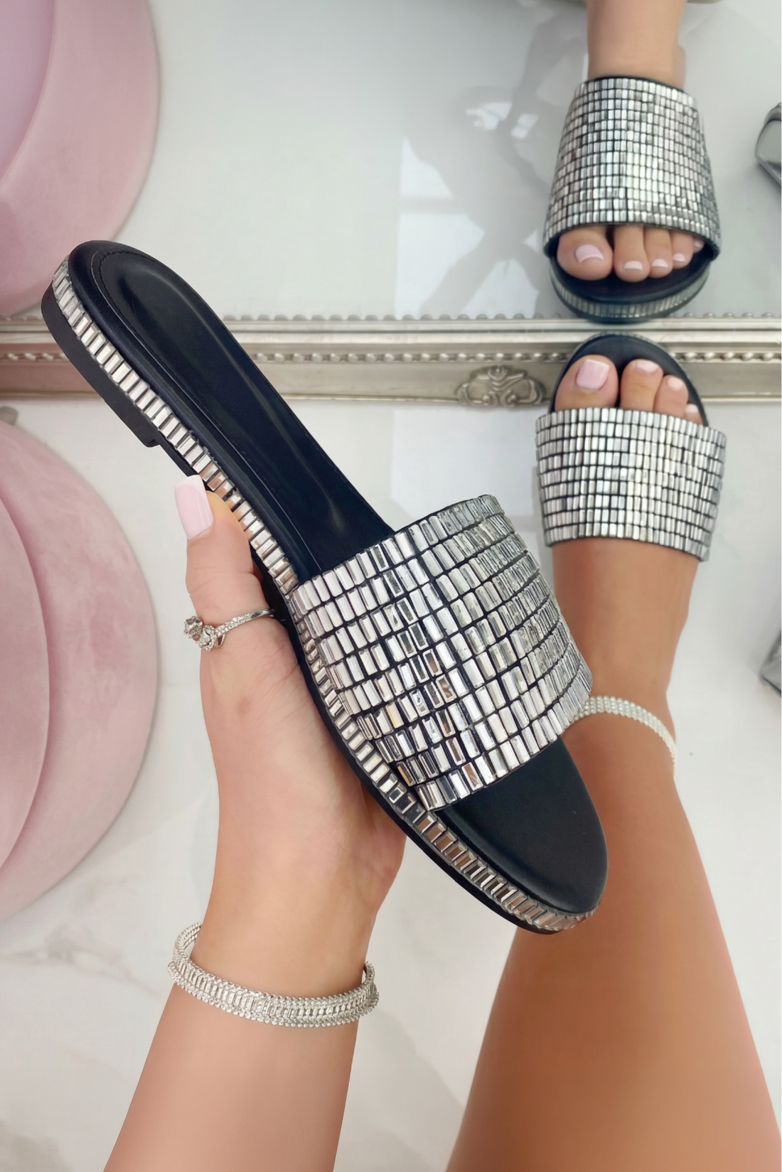Silver embellished sandals worn with a neutral background