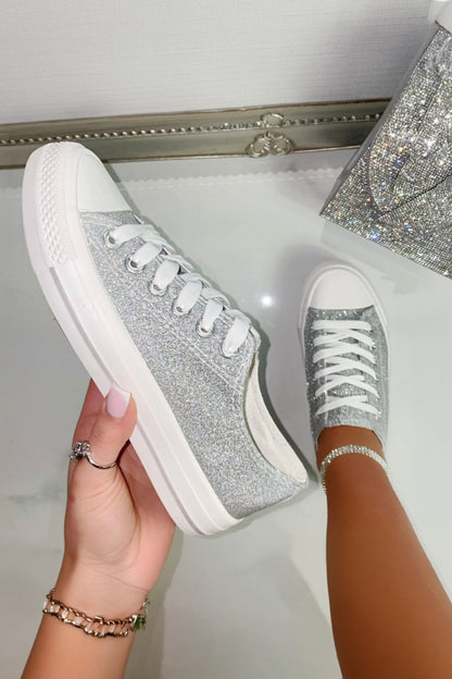 Silver glitter sneakers being held up against a white background
