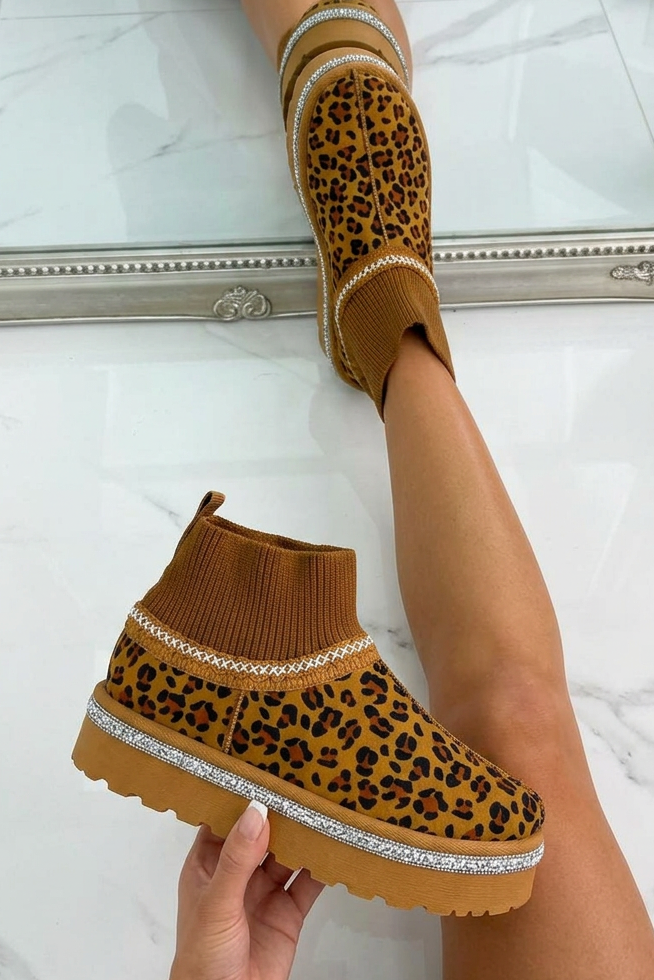 Brown ankle boots with leopard print pattern worn by a person on a light marble floor.