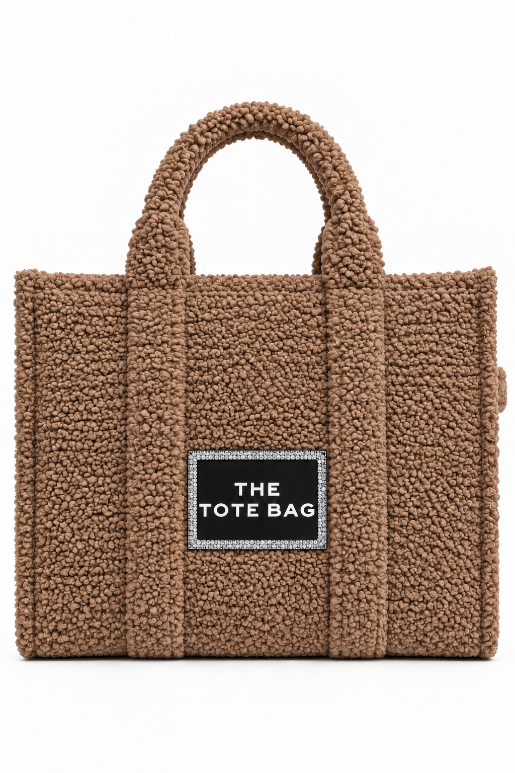 A brown teddy fleece tote bag with dual top handles and a black rectangular label on the front that reads &