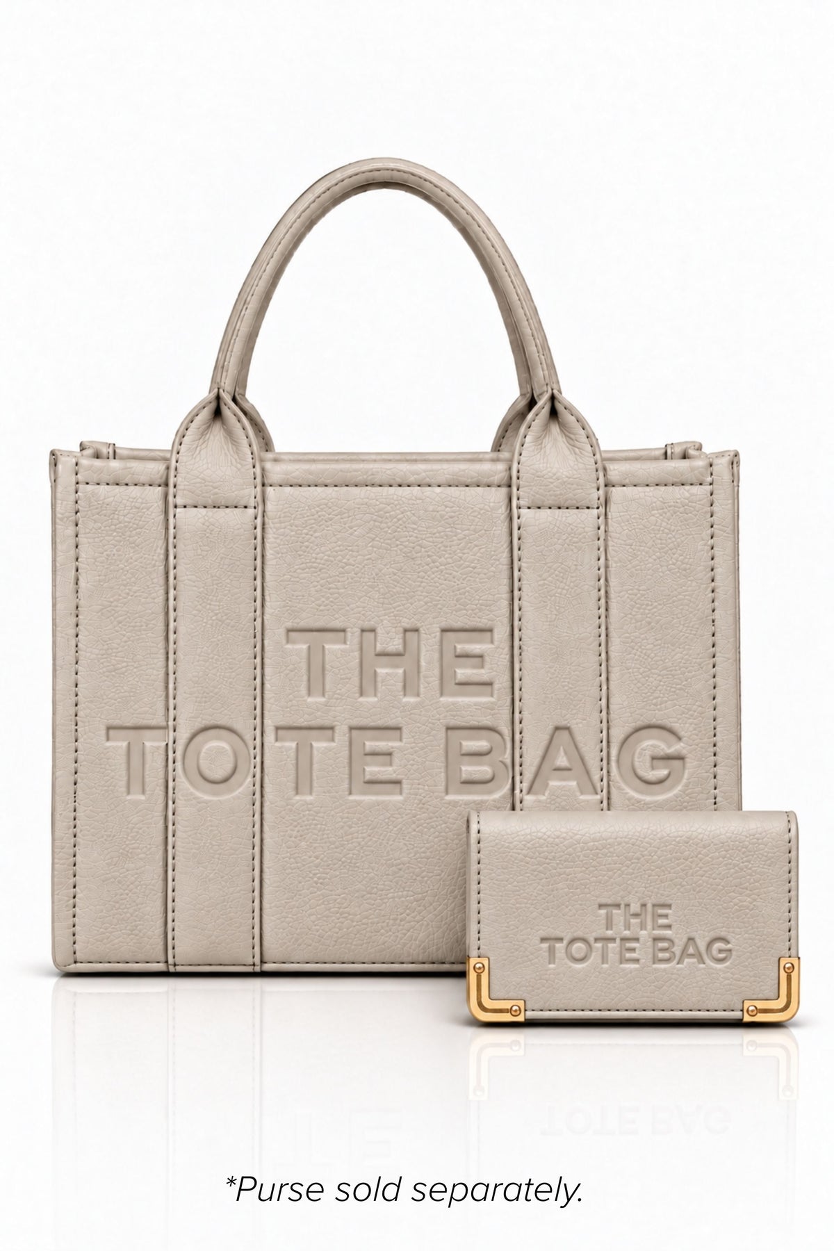 Beige faux leather tote bag with two rounded top handles, embossed "THE TOTE BAG" lettering on the front, contrast stitching. gold tone hardware and a detachable adjustable black shoulder strap. With a beige TOTE purse pictured in front of bag.