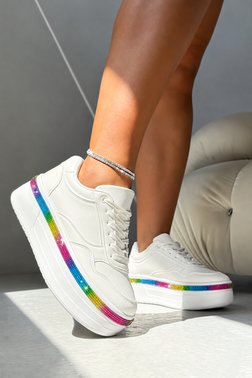White platform sneakers with a vibrant rainbow glitter stripe along the side, shown on a model&