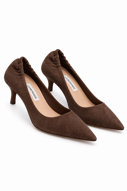 A pair of brown suede pointed-toe pumps with kitten heels, shown on a clean white background. The brand name &