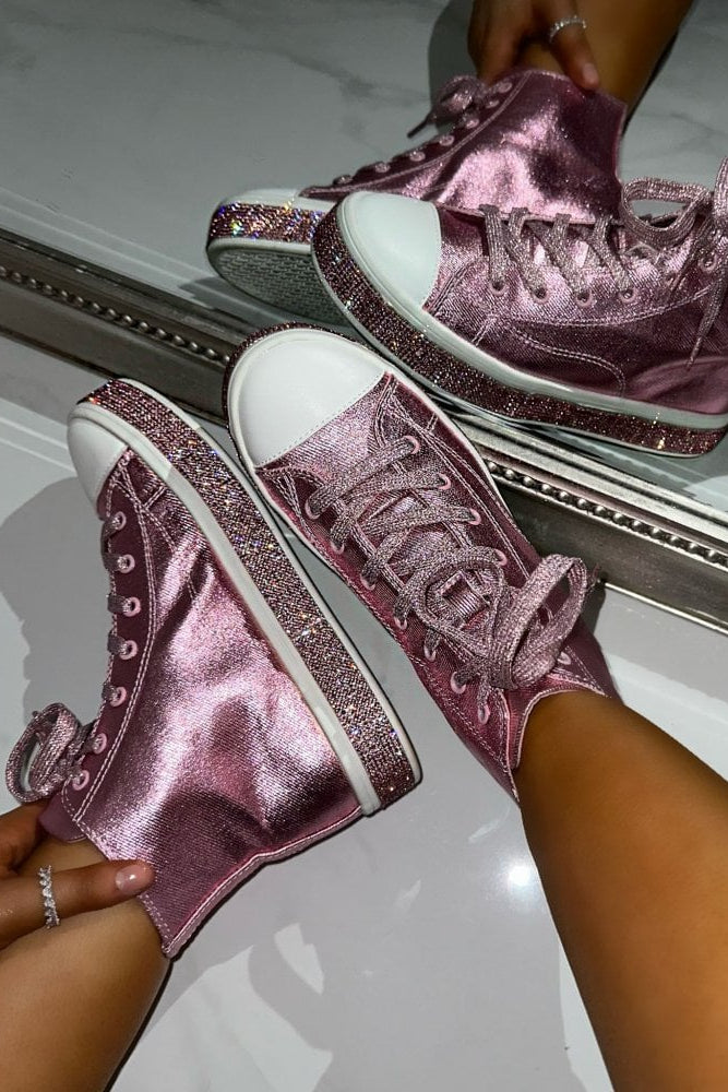 Pink glittery high-top sneakers being worn against a mirror.